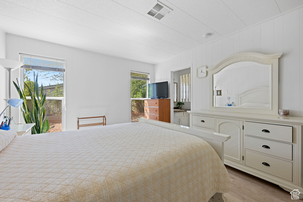 Bedroom featuring access to outside, wood finished floors, and visible vents