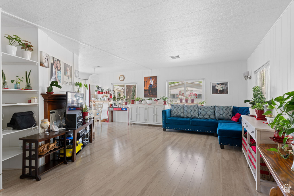 Living area featuring a textured ceiling, wood finished floors, and visible vents