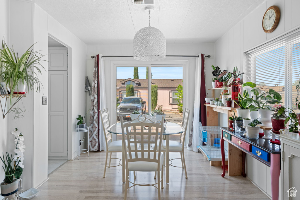 Dining space featuring visible vents, light wood-style flooring, and a chandelier