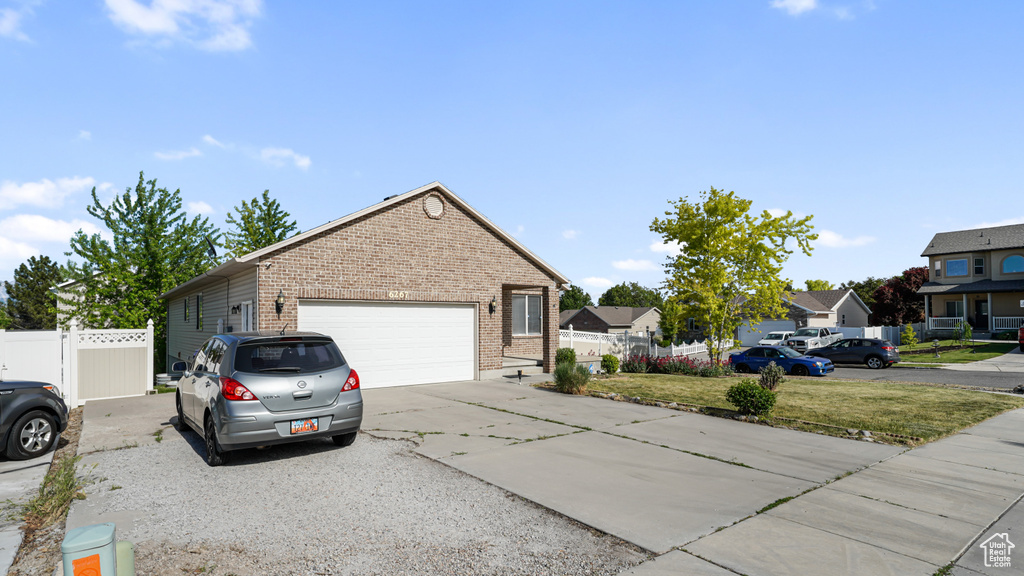 View of front of house featuring brick siding, concrete driveway, and an attached garage