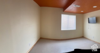 Carpeted empty room with baseboards and visible vents
