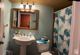 Full bath featuring toilet and a shower with shower curtain