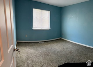 Unfurnished room with baseboards and carpet flooring