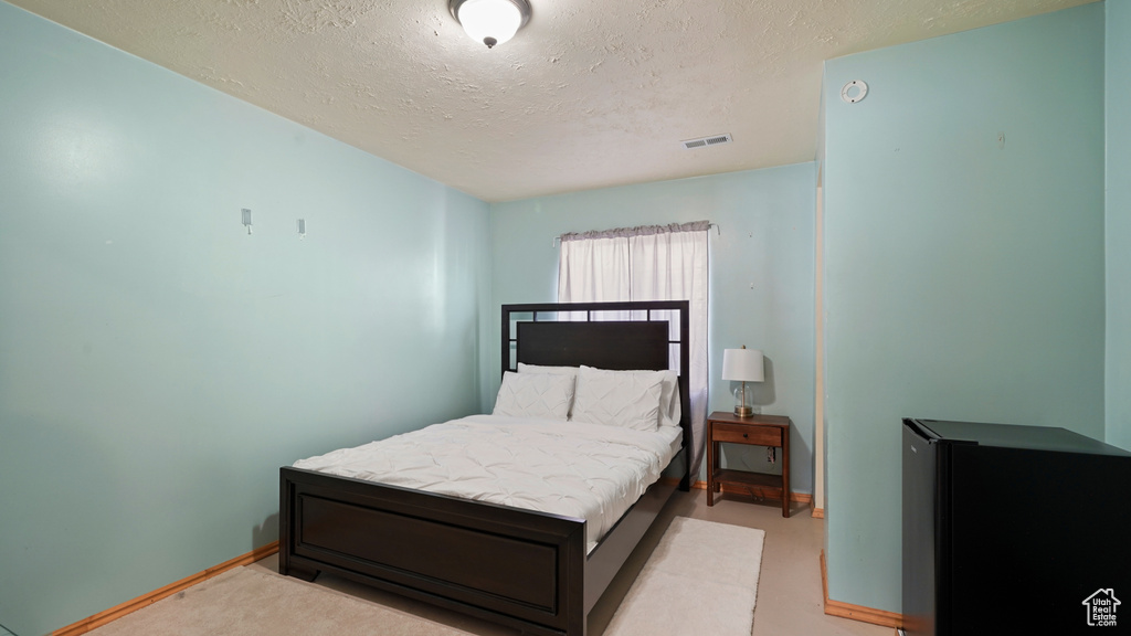 Bedroom with a textured ceiling and baseboards