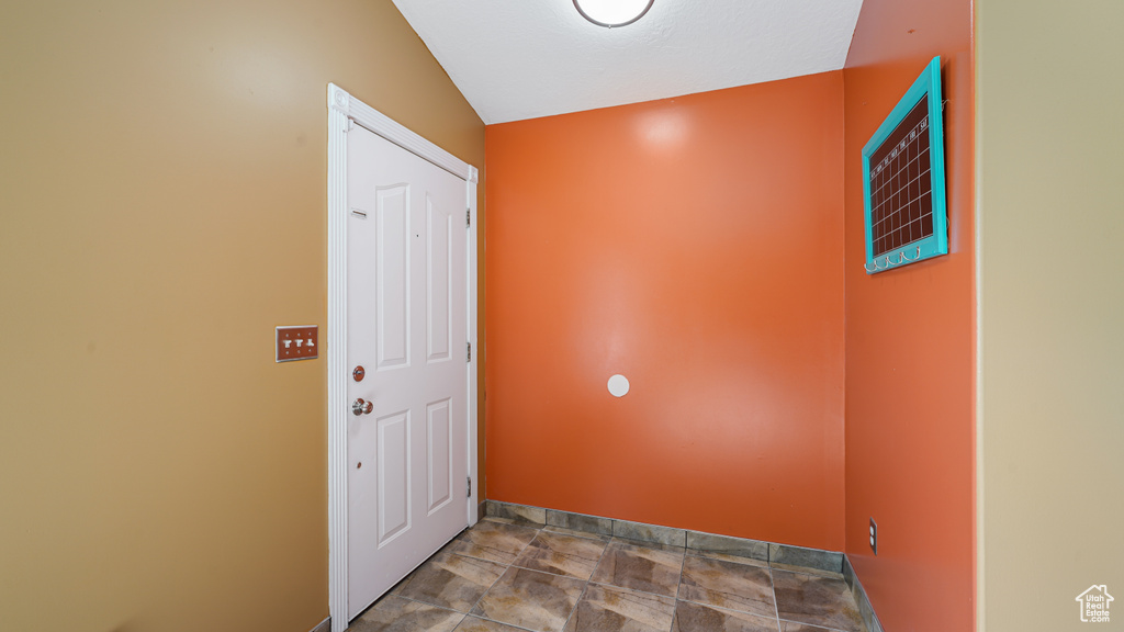Doorway featuring baseboards and stone finish floors