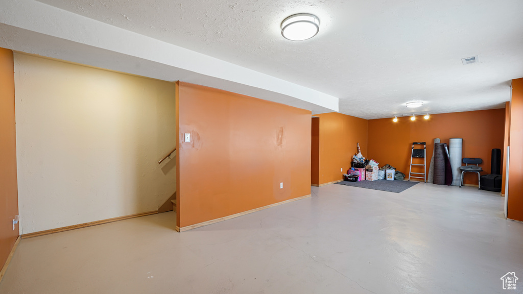 Finished below grade area featuring baseboards and stairway