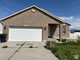 Single story home featuring concrete driveway, brick siding, and an attached garage