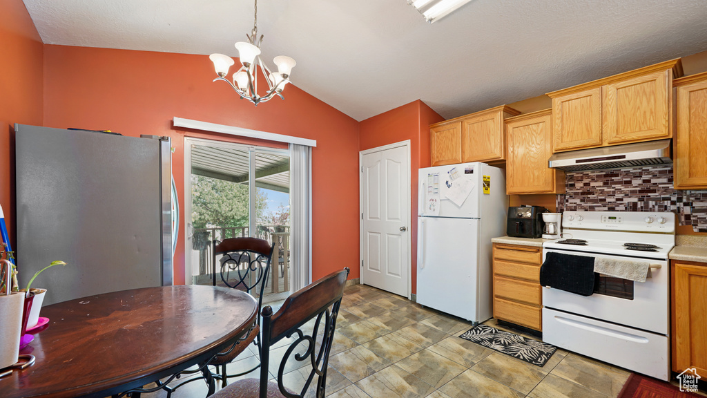 Kitchen with under cabinet range hood, white appliances, lofted ceiling, decorative backsplash, and a chandelier