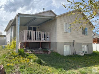 Rear view of property featuring a yard and a deck