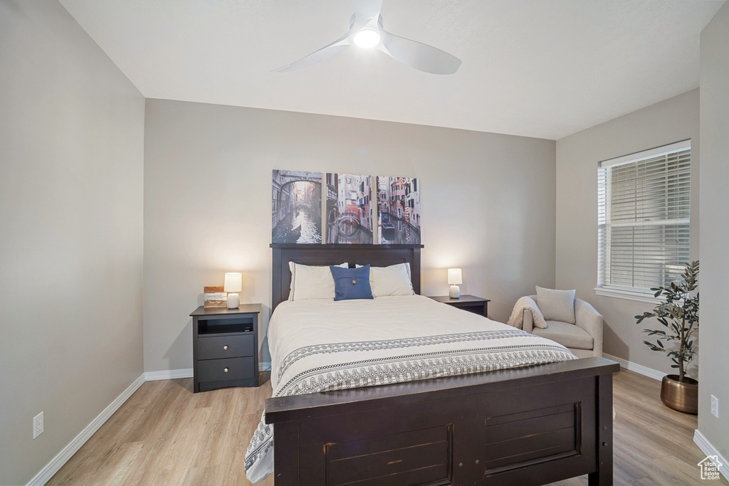 Bedroom featuring baseboards, ceiling fan, and light wood-style flooring