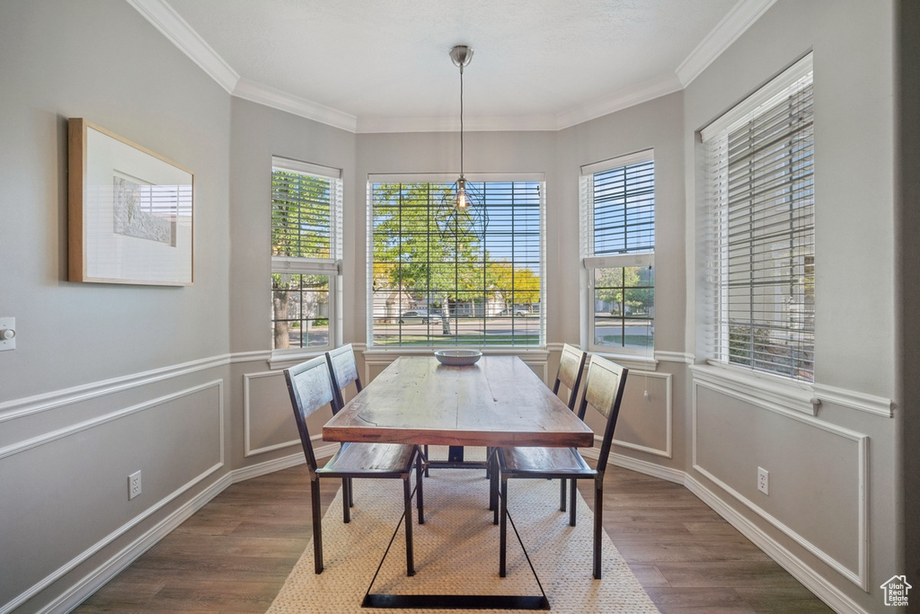 Dining space with crown molding and dark wood finished floors