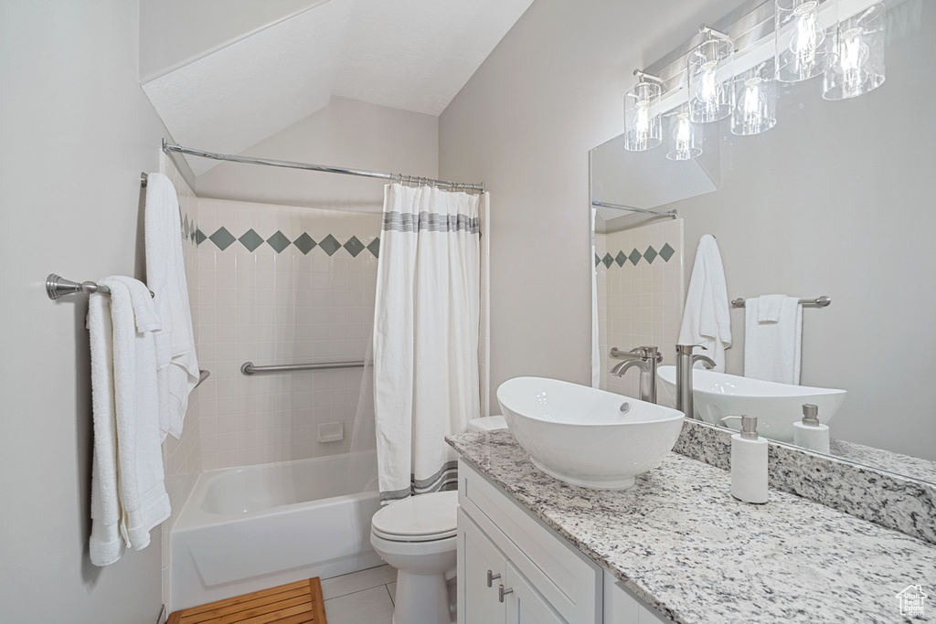 Bathroom featuring vanity, tile patterned flooring, toilet, and shower / tub combo with curtain