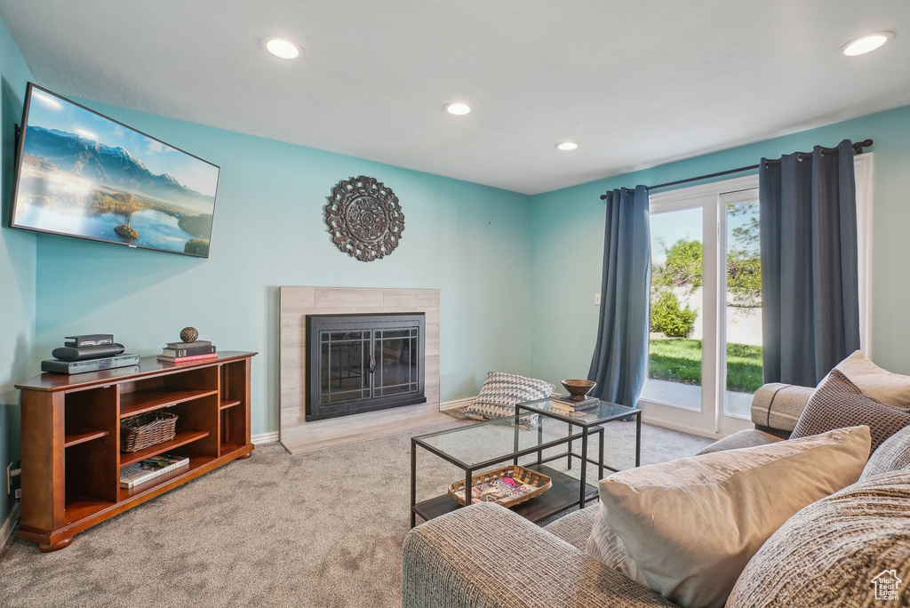 Carpeted living area with recessed lighting, baseboards, and a glass covered fireplace