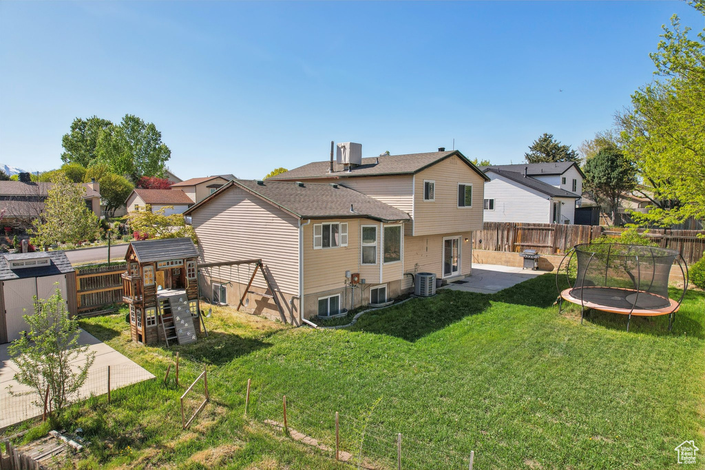 Rear view of house with a playground, a patio, and a fenced backyard