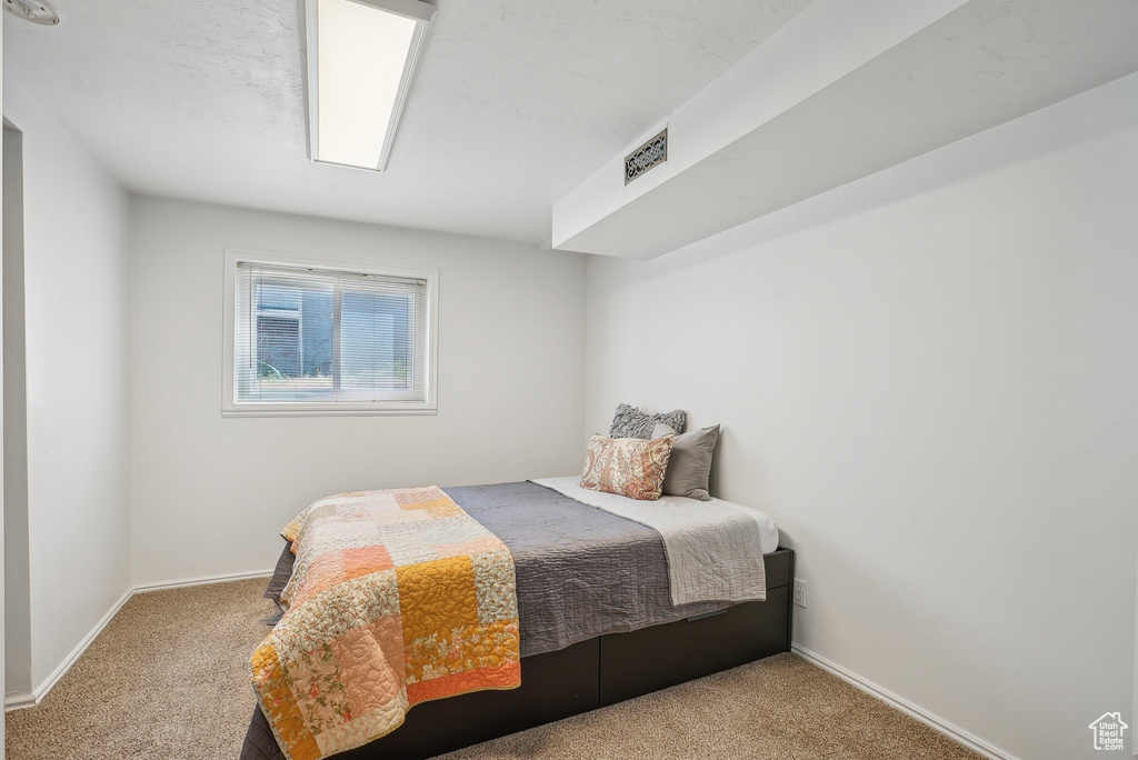 Bedroom featuring carpet floors, baseboards, and visible vents