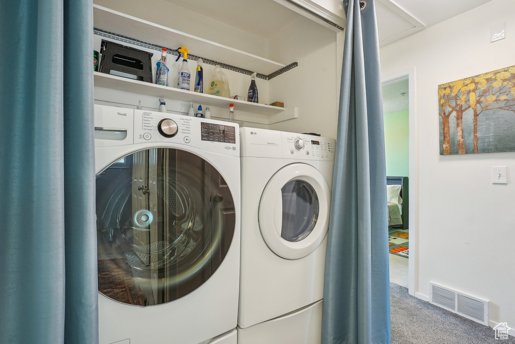 Laundry room with laundry area, carpet floors, visible vents, baseboards, and washing machine and clothes dryer