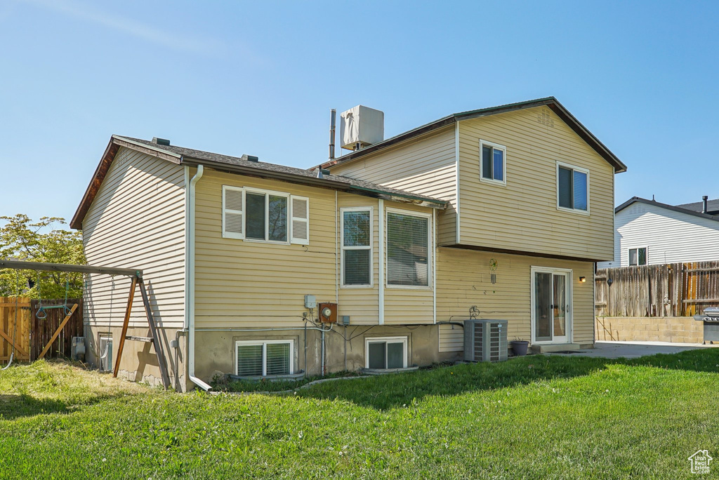 Back of house featuring a lawn, a fenced backyard, and central air condition unit