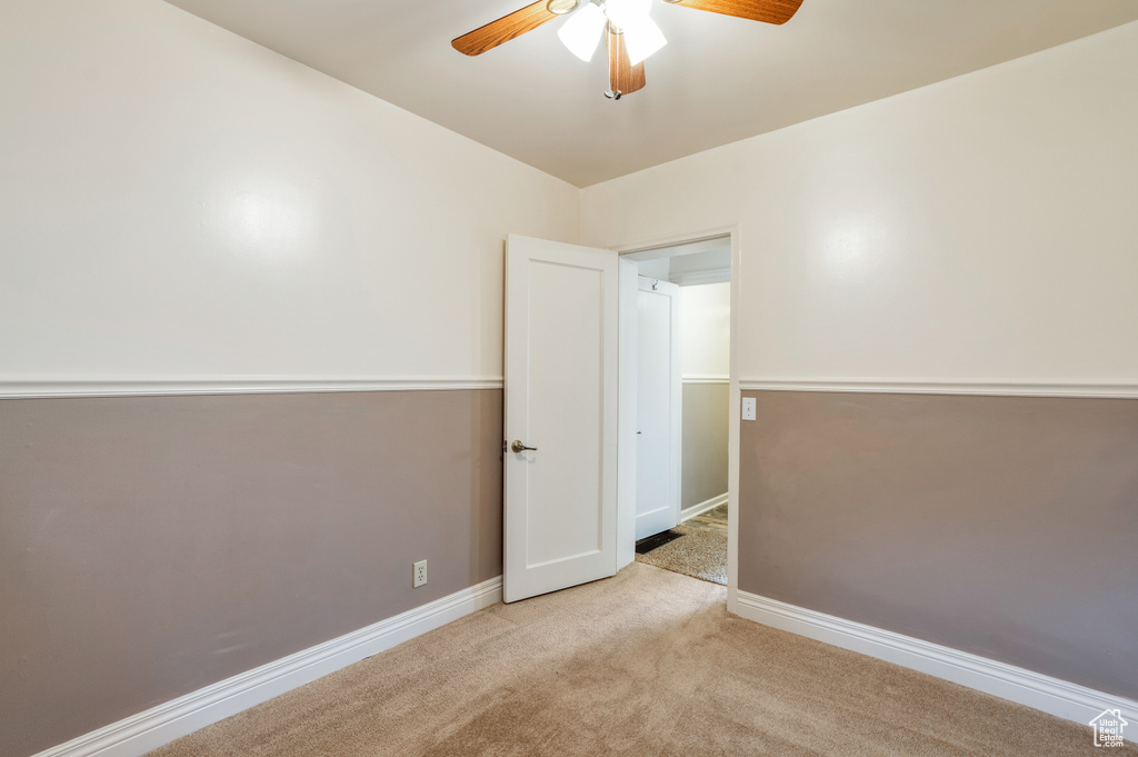Unfurnished room with baseboards, a ceiling fan, and carpet
