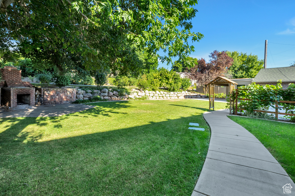 View of yard featuring an outdoor brick fireplace