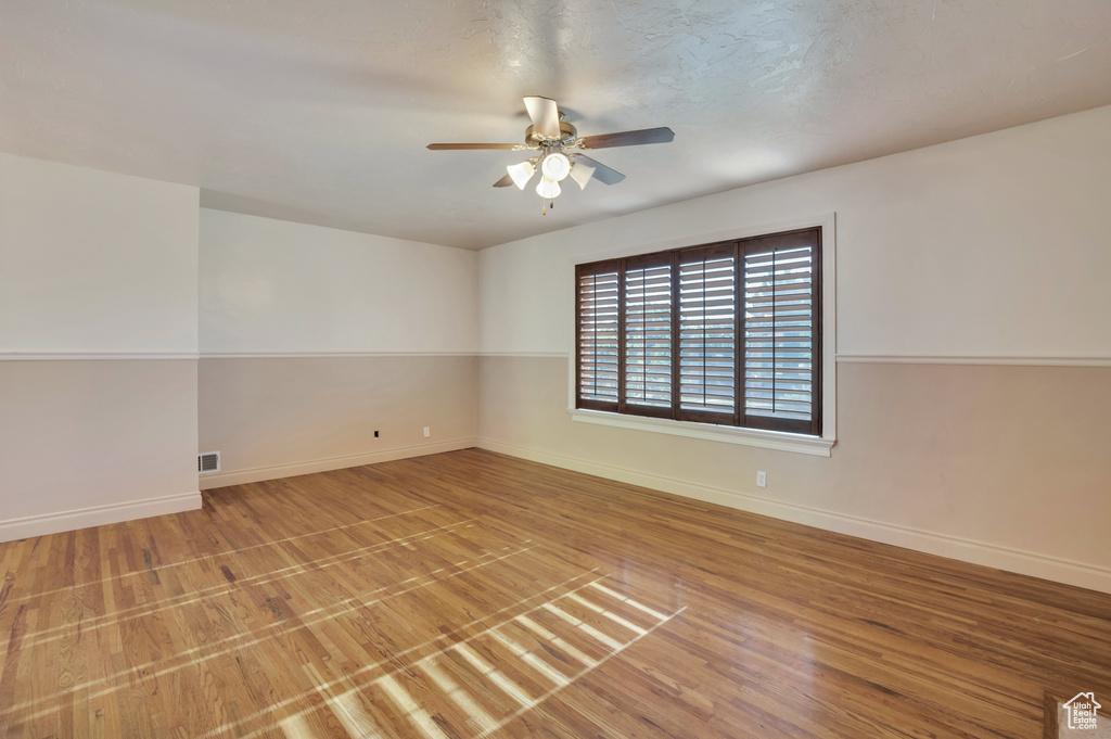Spare room featuring baseboards, a ceiling fan, light wood finished floors, and visible vents