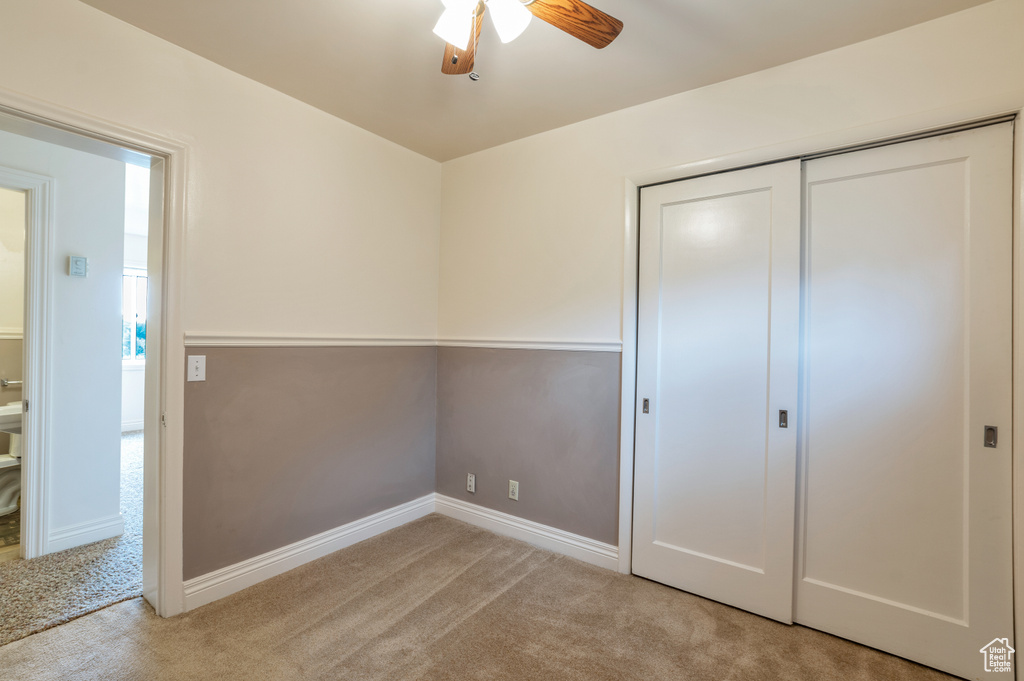 Unfurnished bedroom featuring a ceiling fan, baseboards, light carpet, and a closet