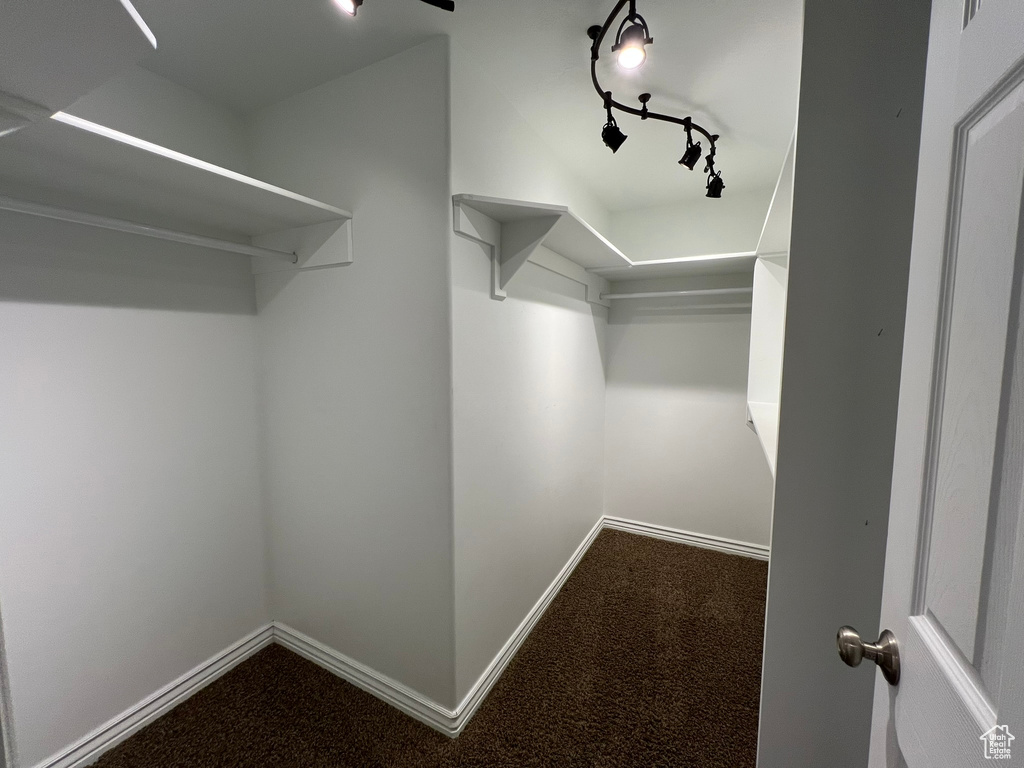 Walk in closet with dark carpet