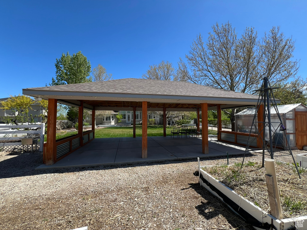 Exterior space with fence, an outbuilding, a gazebo, and a greenhouse
