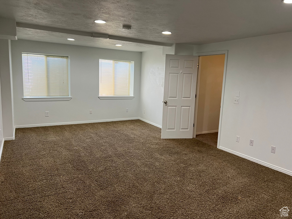 Unfurnished room featuring recessed lighting, baseboards, and dark carpet