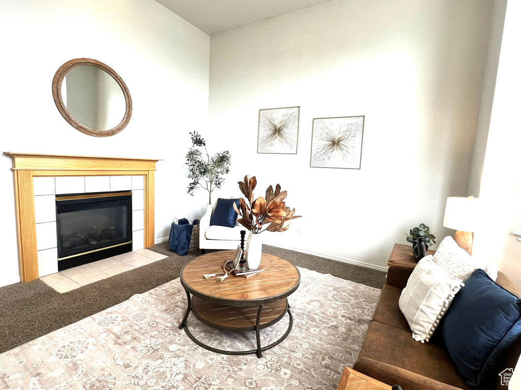 Carpeted living area featuring baseboards and a tile fireplace