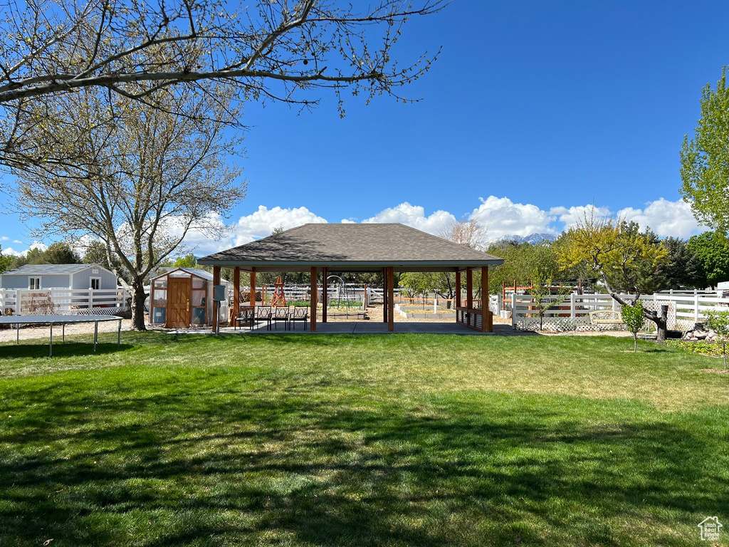 View of property\\\'s community featuring a trampoline, a storage shed, an outbuilding, a gazebo, and fence