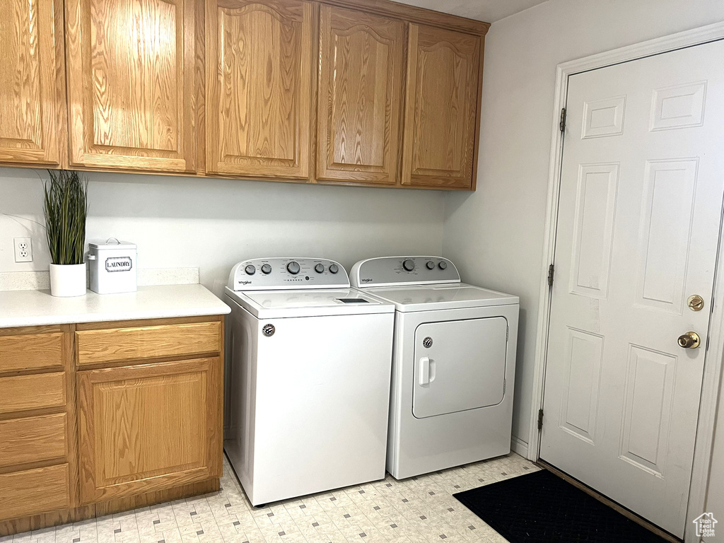 Laundry room featuring cabinet space, washing machine and clothes dryer, and light floors