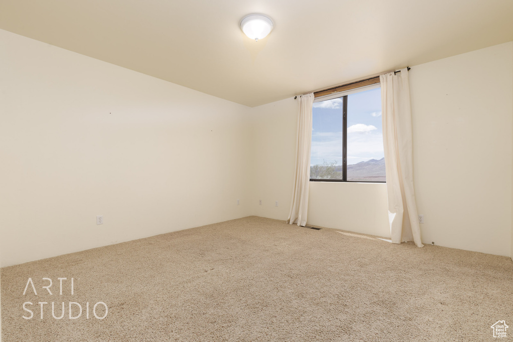 Carpeted spare room featuring a mountain view
