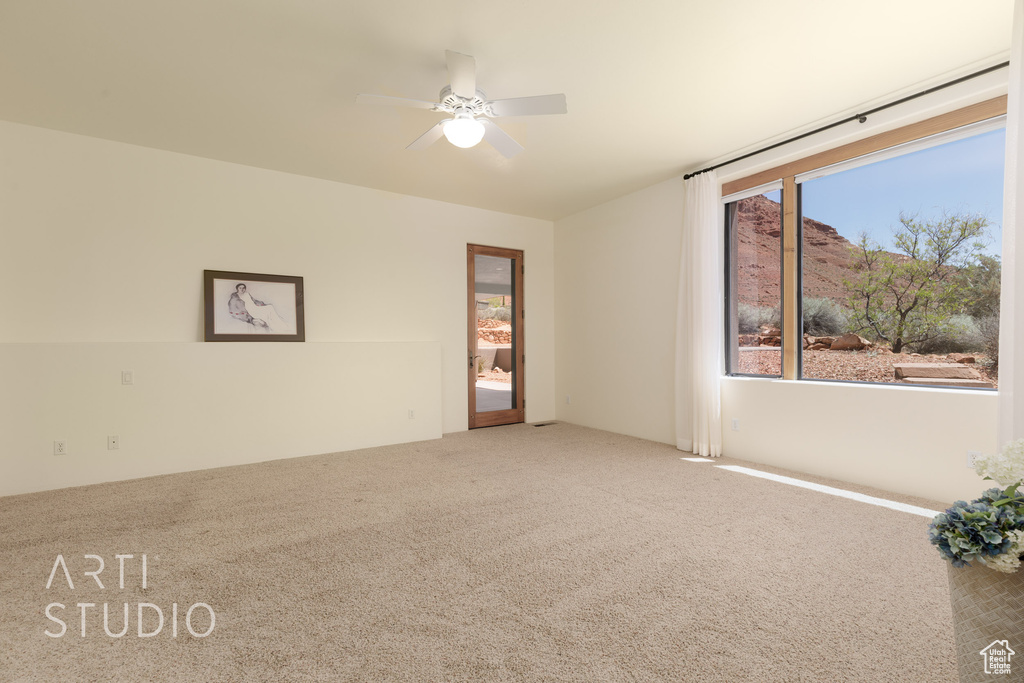 Unfurnished room featuring carpet floors and ceiling fan
