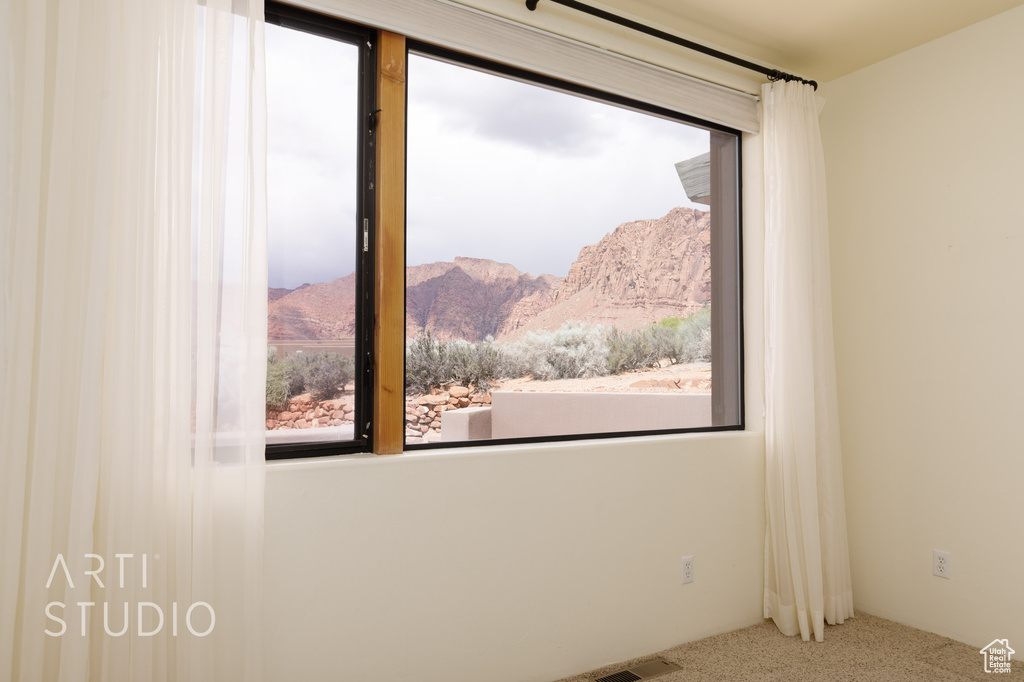 Empty room featuring carpet, a mountain view, and visible vents