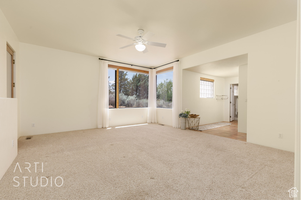 Unfurnished room featuring a ceiling fan and carpet
