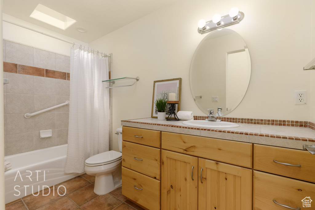 Full bath with tile patterned flooring, shower / bathtub combination with curtain, toilet, and vanity