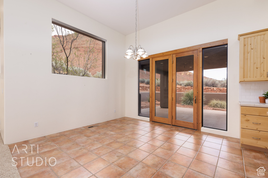 Unfurnished dining area with french doors and a notable chandelier
