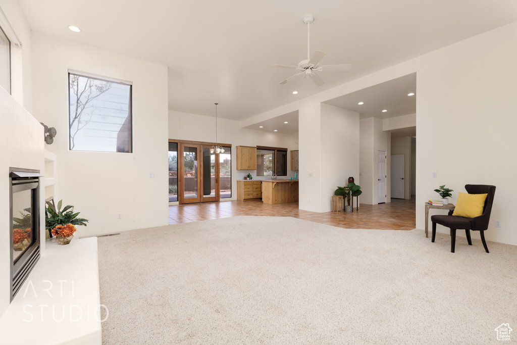 Living area with recessed lighting, ceiling fan, and light colored carpet