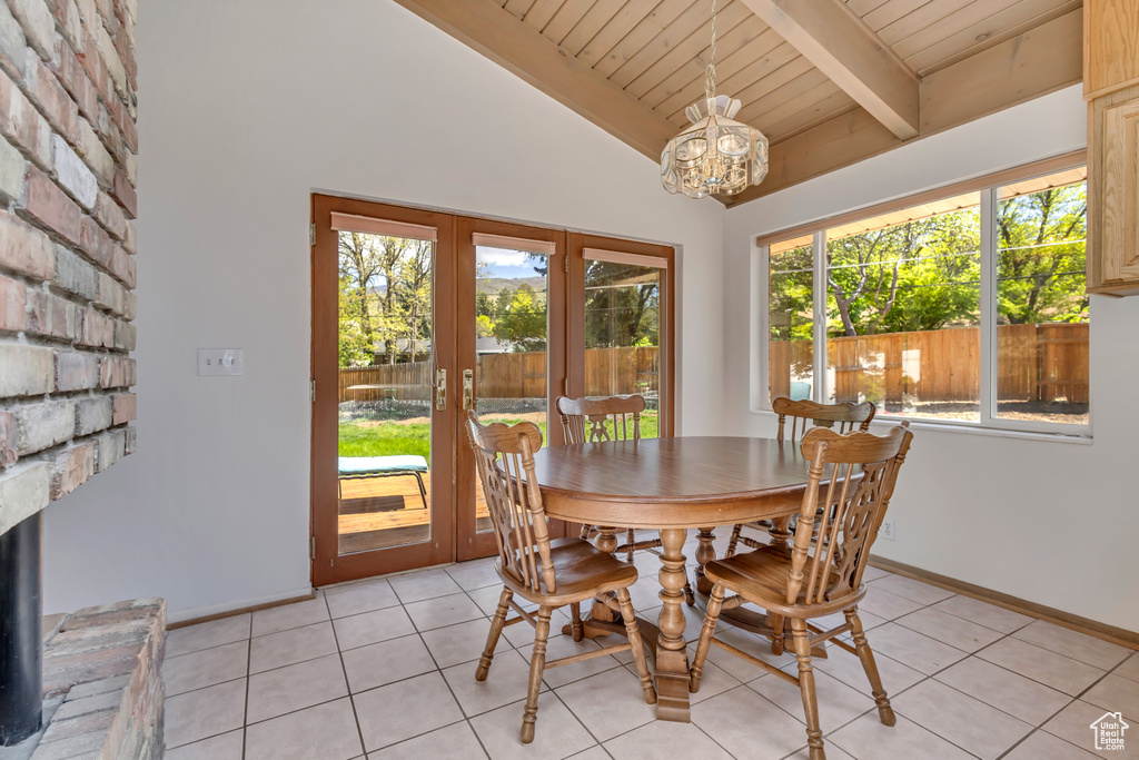Dining space with baseboards, vaulted ceiling with beams, wooden ceiling, french doors, and a notable chandelier