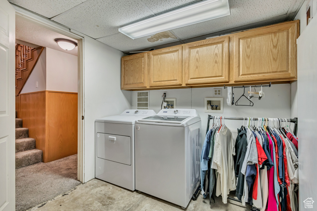 Laundry area with cabinet space, wainscoting, and washer and dryer