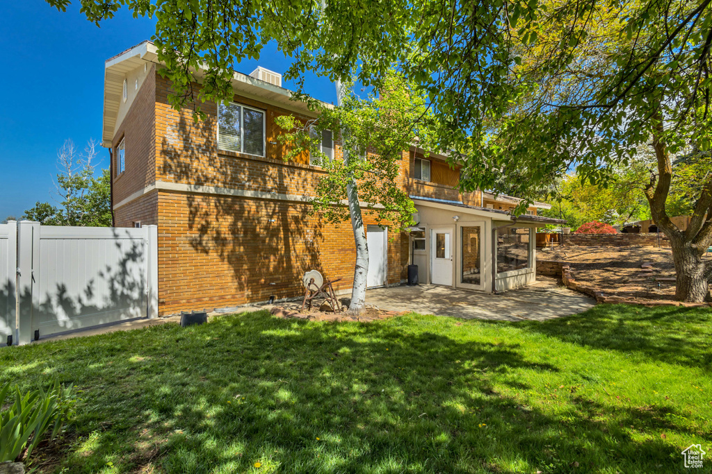 Rear view of property featuring brick siding and a patio