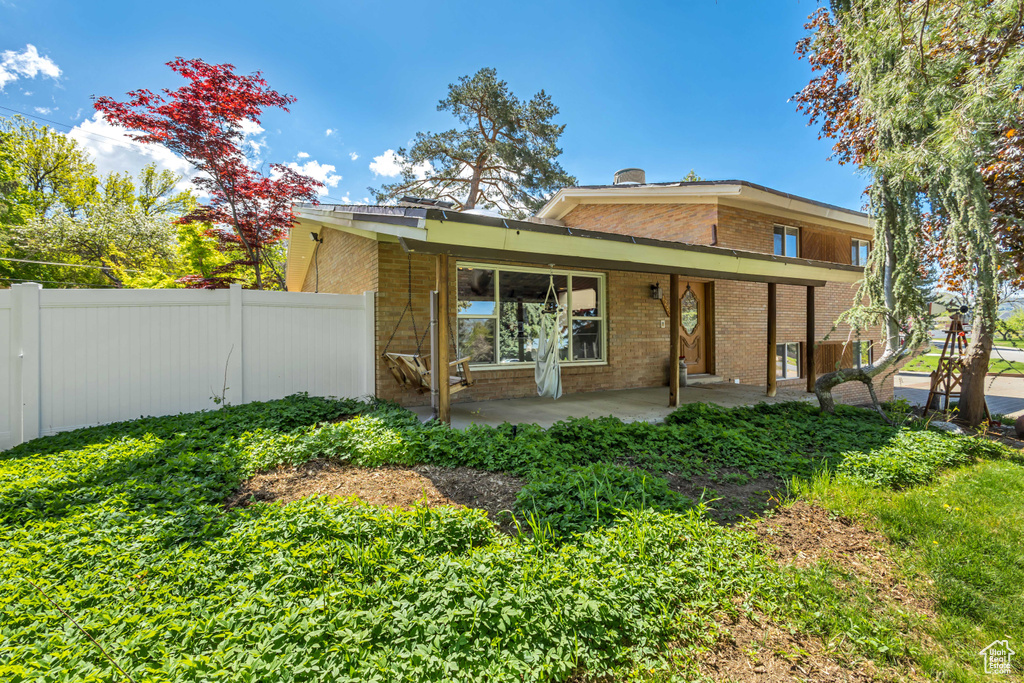 Rear view of house with brick siding and fence