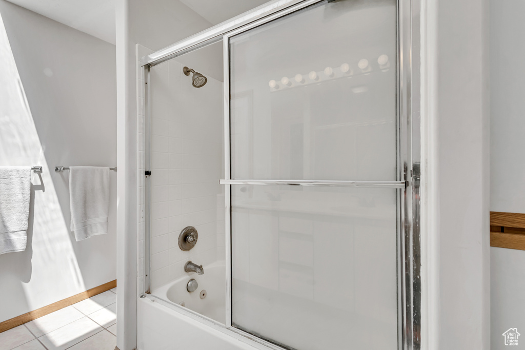 Full bath featuring enclosed tub / shower combo and tile patterned floors