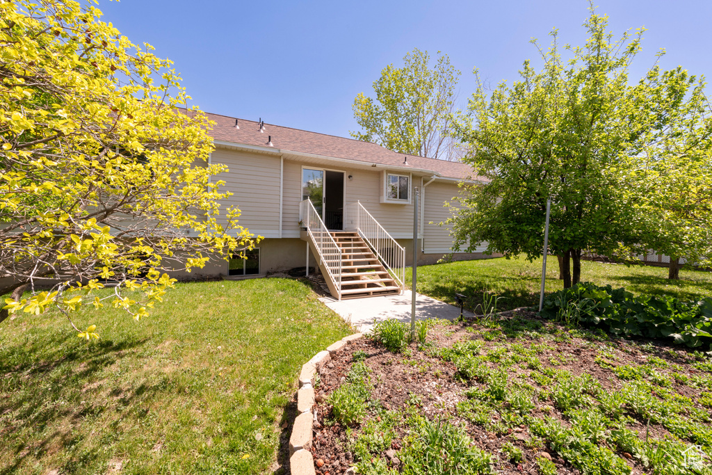Rear view of property with a lawn