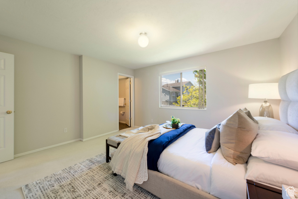 Carpeted bedroom with baseboards and connected bathroom