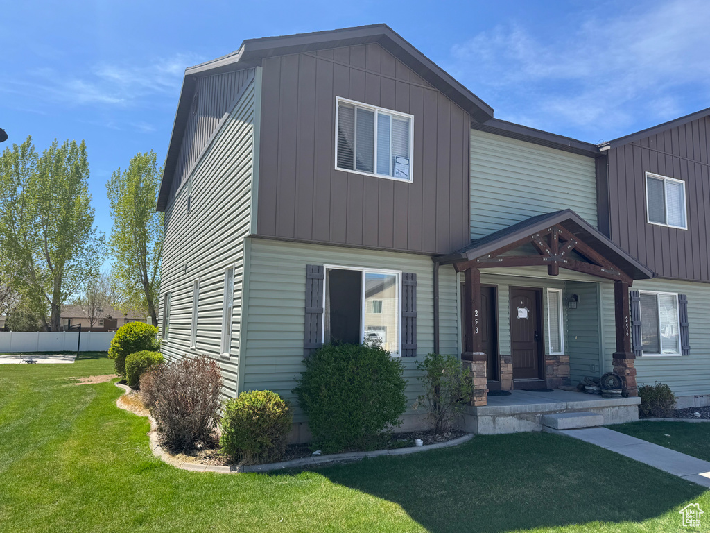 View of front of property featuring a porch and a front yard