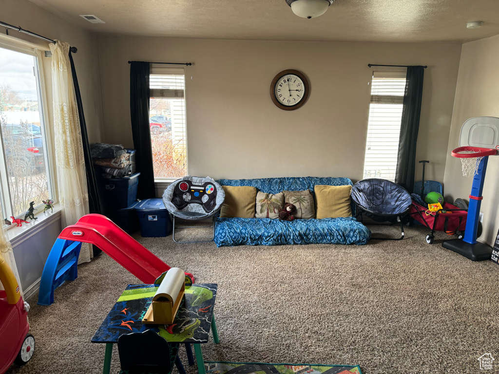 Recreation room featuring visible vents, plenty of natural light, and carpet