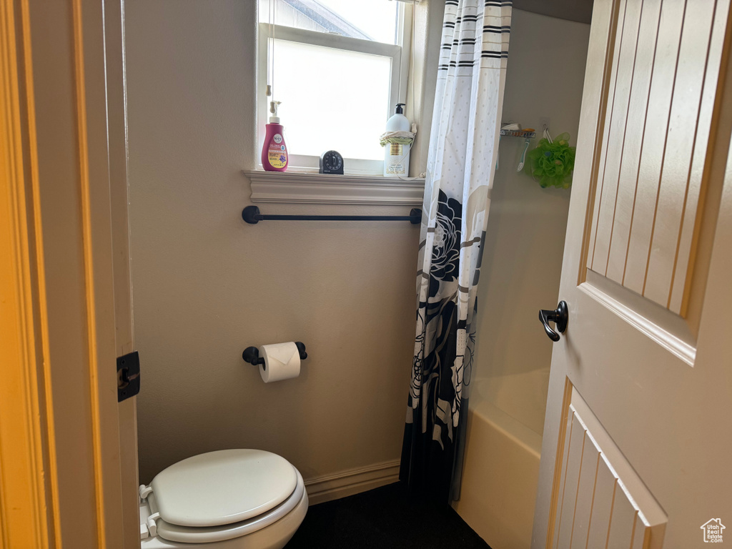 Bathroom featuring shower / bath combo with shower curtain and toilet