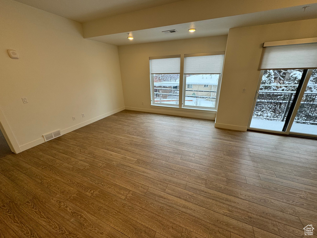 Empty room with visible vents, baseboards, and wood finished floors