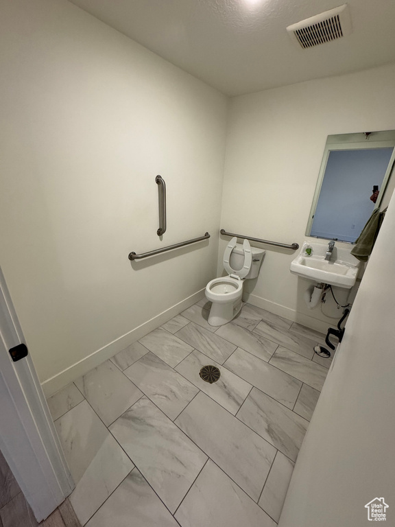 Bathroom with visible vents, a sink, marble finish floor, and baseboards